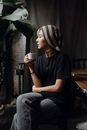 Slender Asian female having cup of coffee in quiet cafe