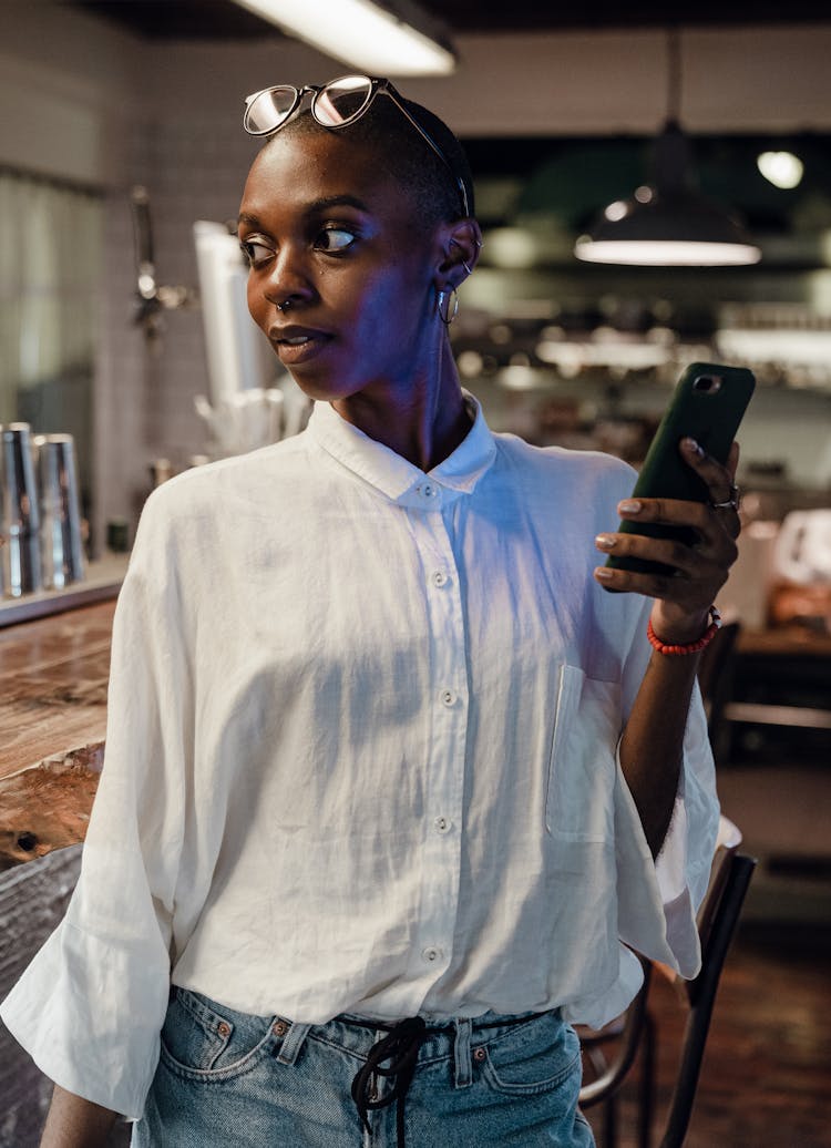 Trendy Black Woman With Cellphone In Cafe