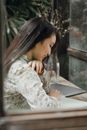 Asian female student studying in modern cafe