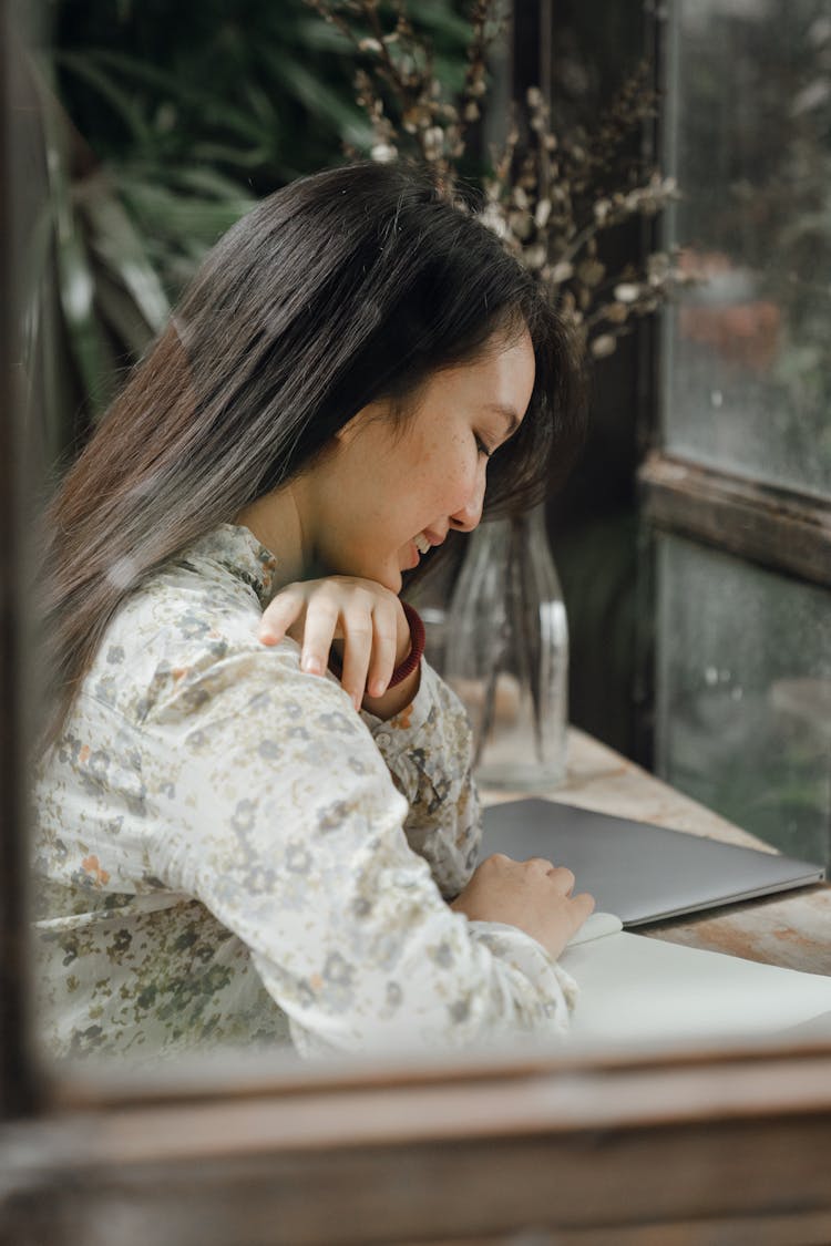 Asian Female Student Studying In Modern Cafe