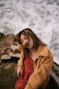 Woman in Brown Coat Standing on Brown Rock