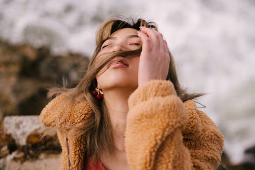 A Woman Wearing Fur Jacket While Eyes Closed 