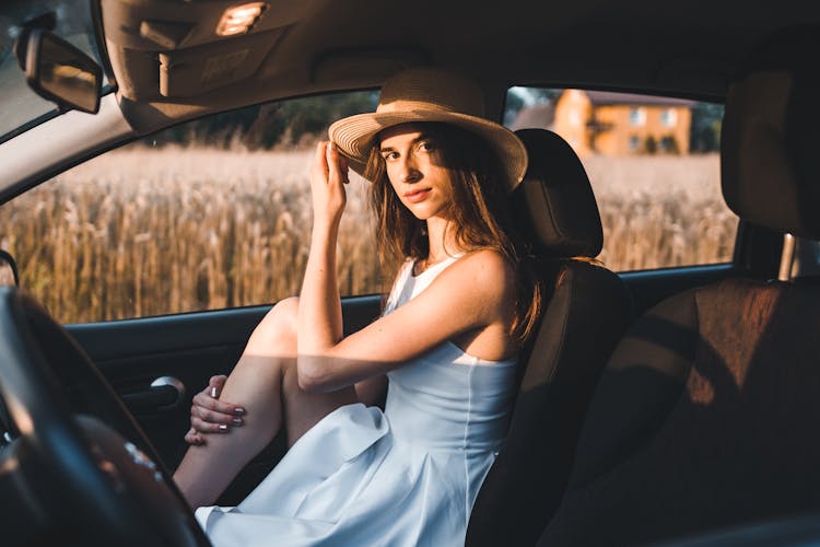 A Woman In White Dress Sitting In The Car