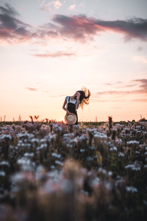 Free Woman in Black and White Dress on Brown Grass Field during Sunset Stock Photo