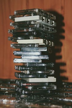 A nostalgic stack of vintage cassette tapes on a wooden surface indoors.