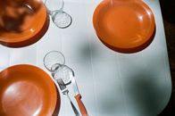 Stainless Steel Fork and Bread Knife on Orange Ceramic Plate