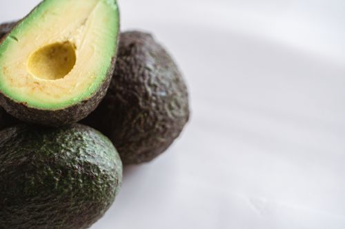 Free From above of similar ripe tropical avocados with rough skin and tender pulp on white background Stock Photo