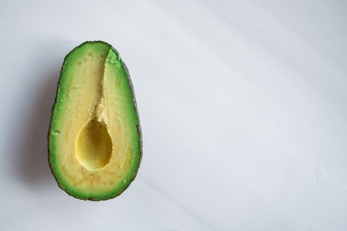 Free Overhead of tasty half avocado with bright green pulp and hole in center on white table Stock Photo