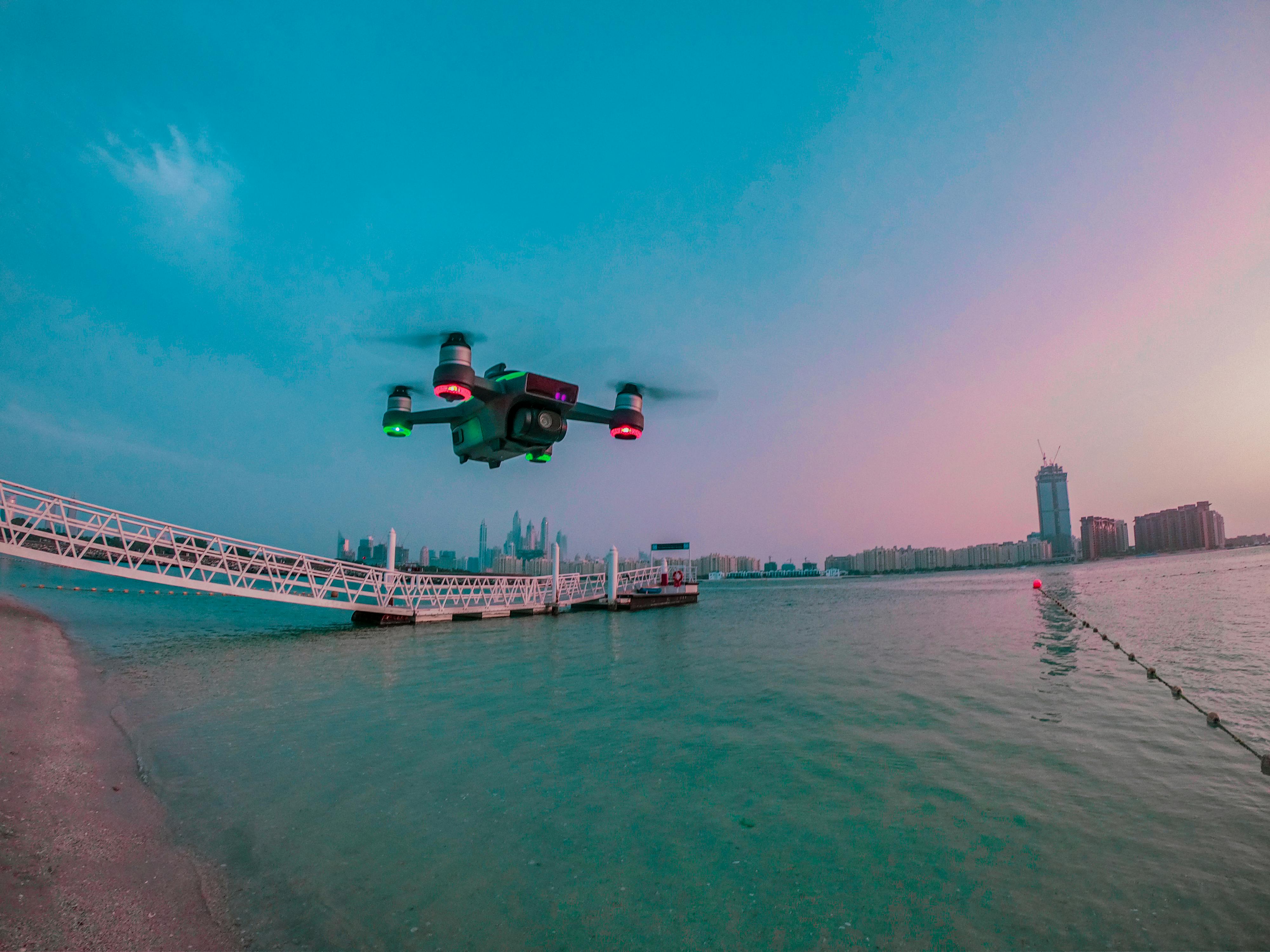 modern drone filming video while flying above city river
