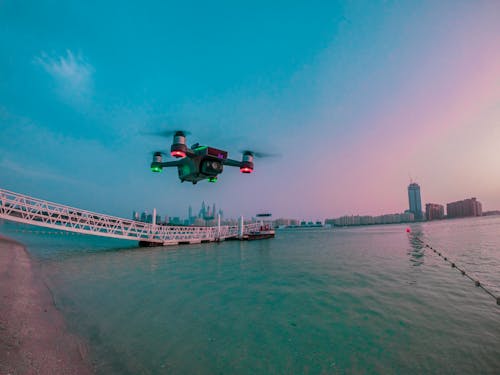 Modern drone filming video while flying above city river