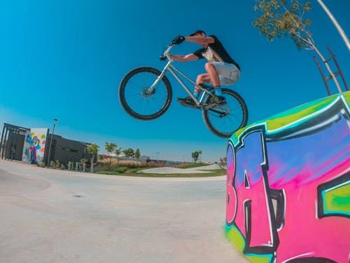 Unrecognizable cyclist performing trick on bicycle on street