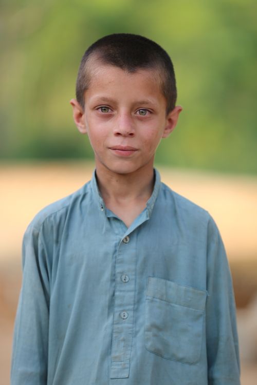 Free A serious young boy wearing blue long sleeves, outdoors in Pakistan. Stock Photo