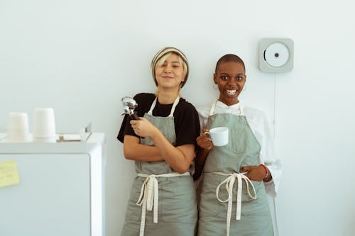 Delighted baristas with portafilter and cup