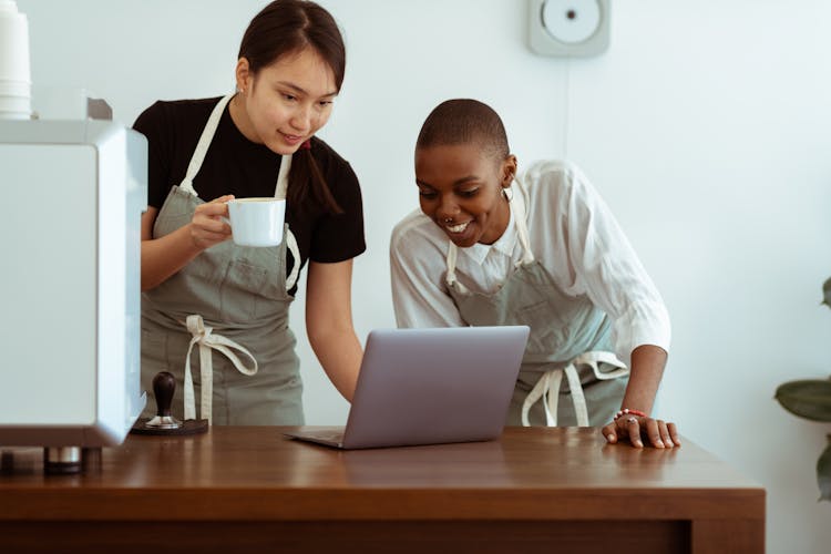 Happy Cafe Colleagues Surfing Laptop In Kitchen