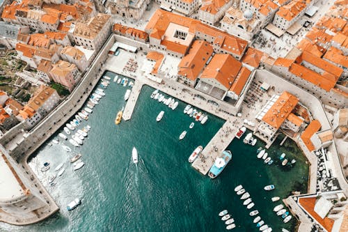 Free Breathtaking drone view of coastal town with traditional red roofed buildings and harbor with moored boats in Croatia Stock Photo