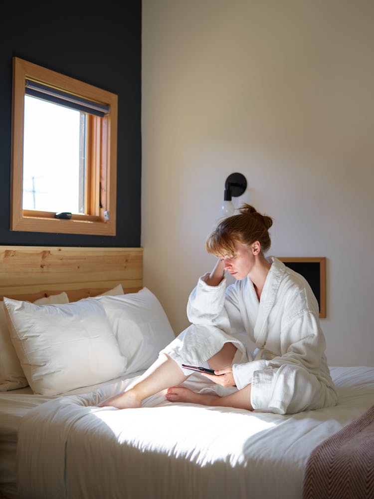 Relaxed Woman In White Bathrobe Reading Ebook