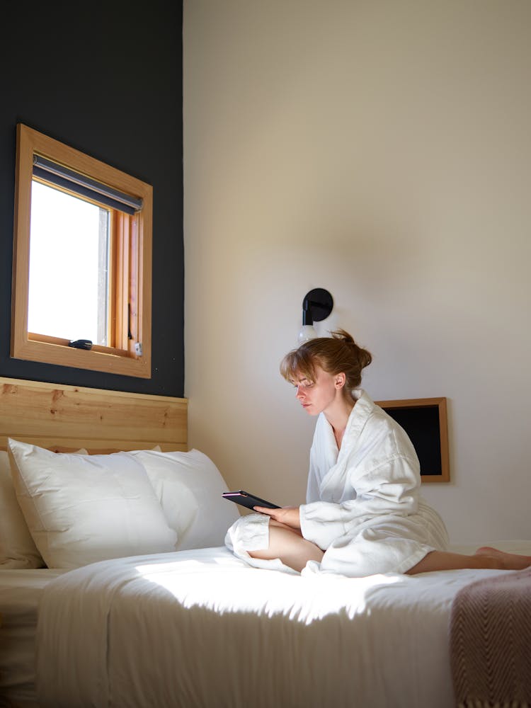 Relaxed Woman In Bathrobe Using E Reader