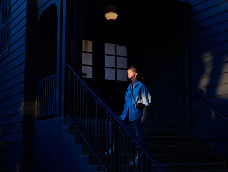 Woman On House Entrance Stairs At Night