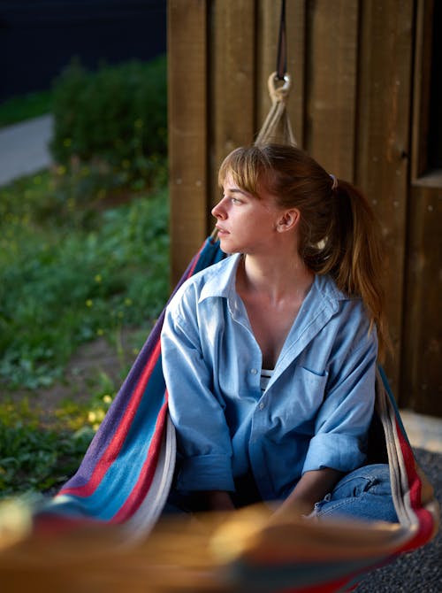 Positive woman sitting in hammock