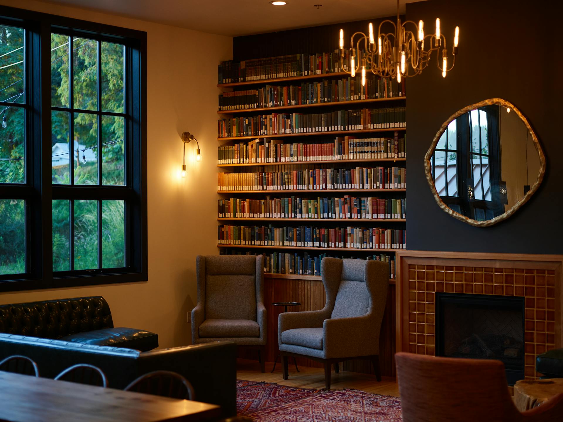 A cozy library interior with bookshelves and a warm fireplace