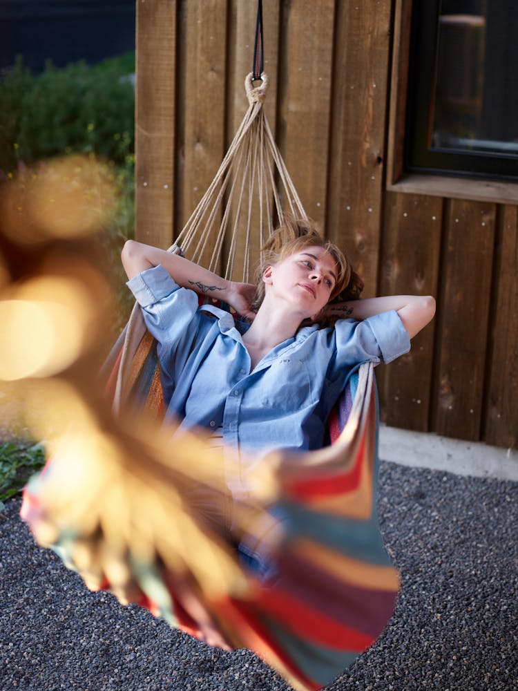 Carefree Woman Resting In Hammock In Backyard