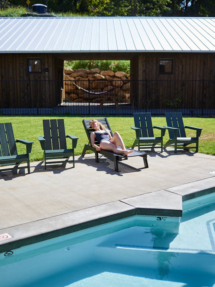 Relaxed Woman Sunbathing On Lounger On Poolside