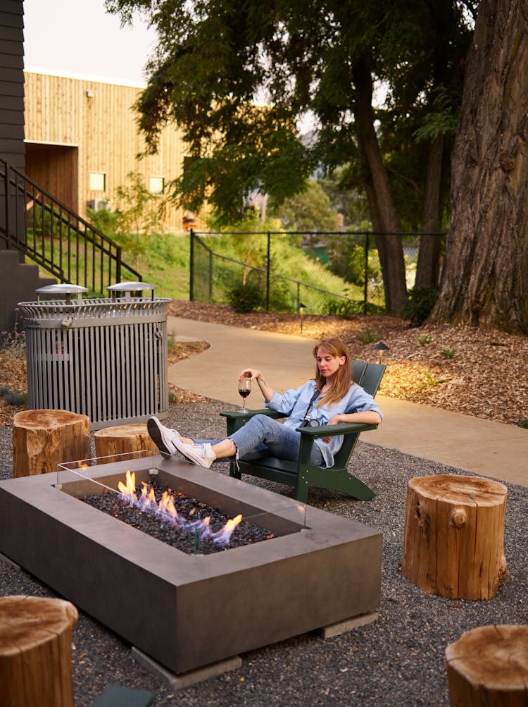 Woman With Glass Of Wine Resting In Cozy Backyard