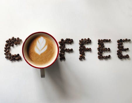 Flat lay of coffee latte with beans spelling COFFEE. Perfect copy space for beverage themes.