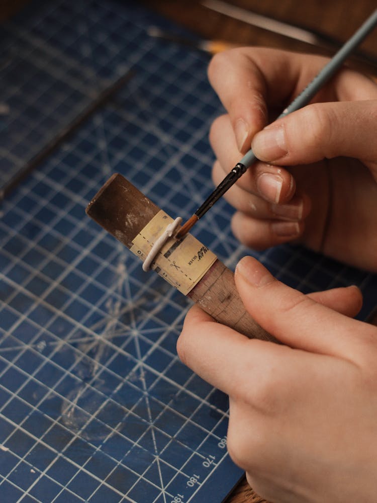 A Person Holding A Wood And Brush