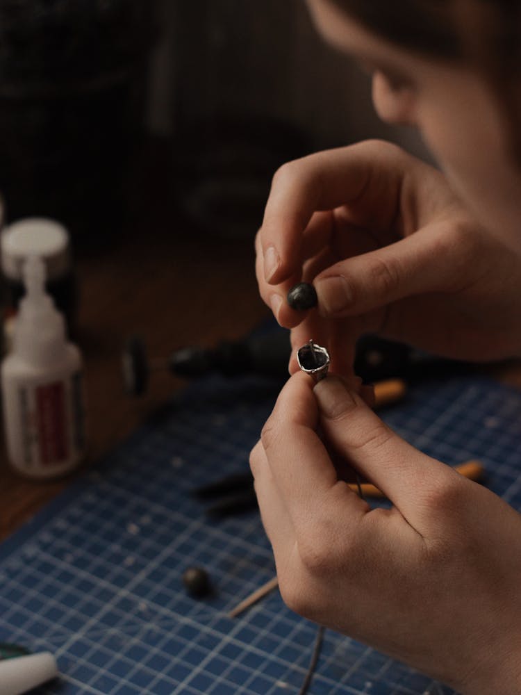 Person Holding Tiny Silver And Black Objects