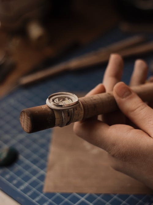 Person Holding a Wooden Tube With a Ring Mold