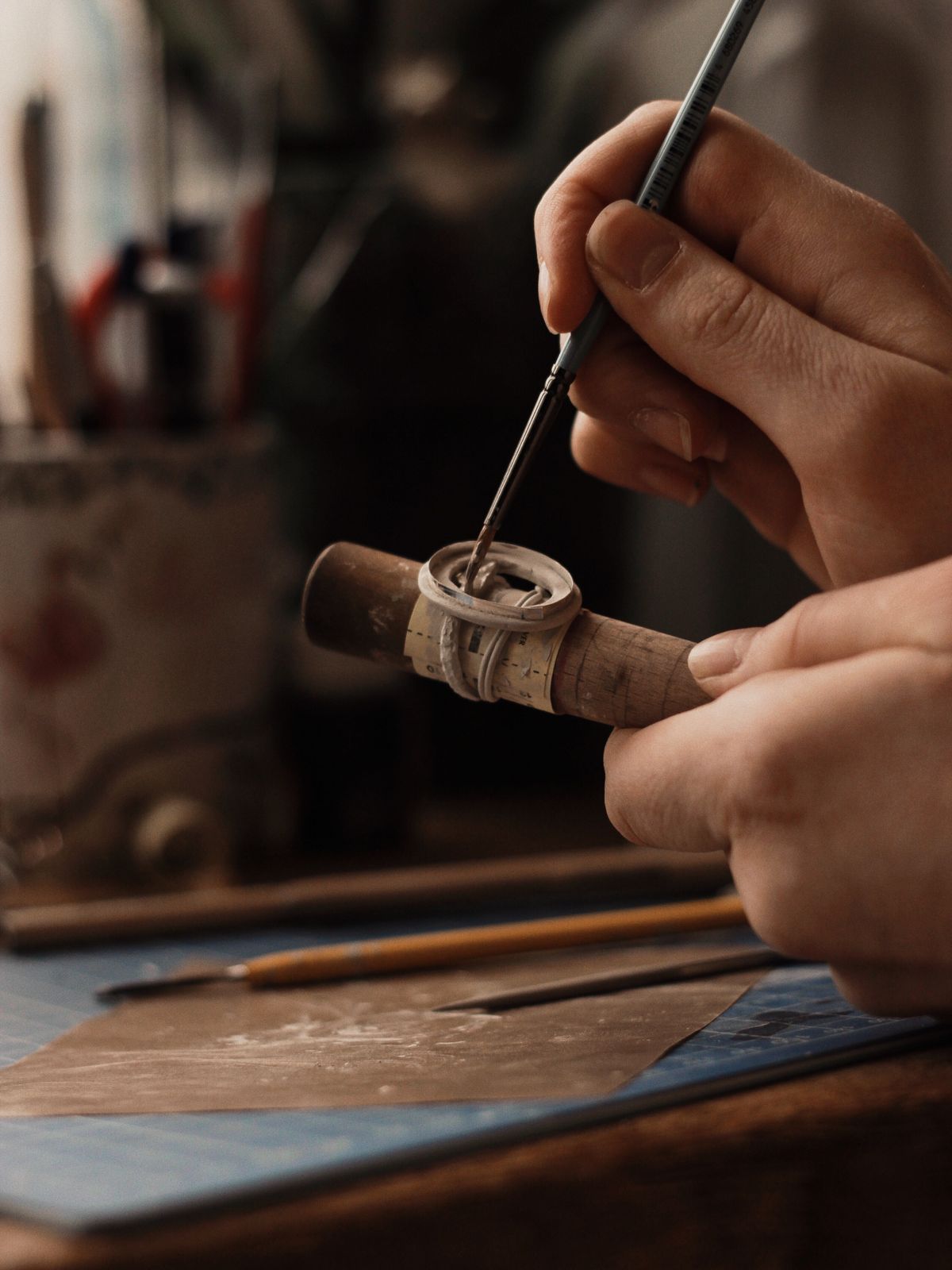 Hands carefully working on jewelry in a minimal studio