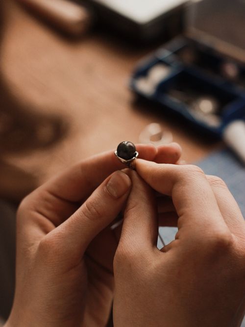 Free Close-up of hands crafting a silver ring, featuring dark stone. Artistic jewelry making. Stock Photo
