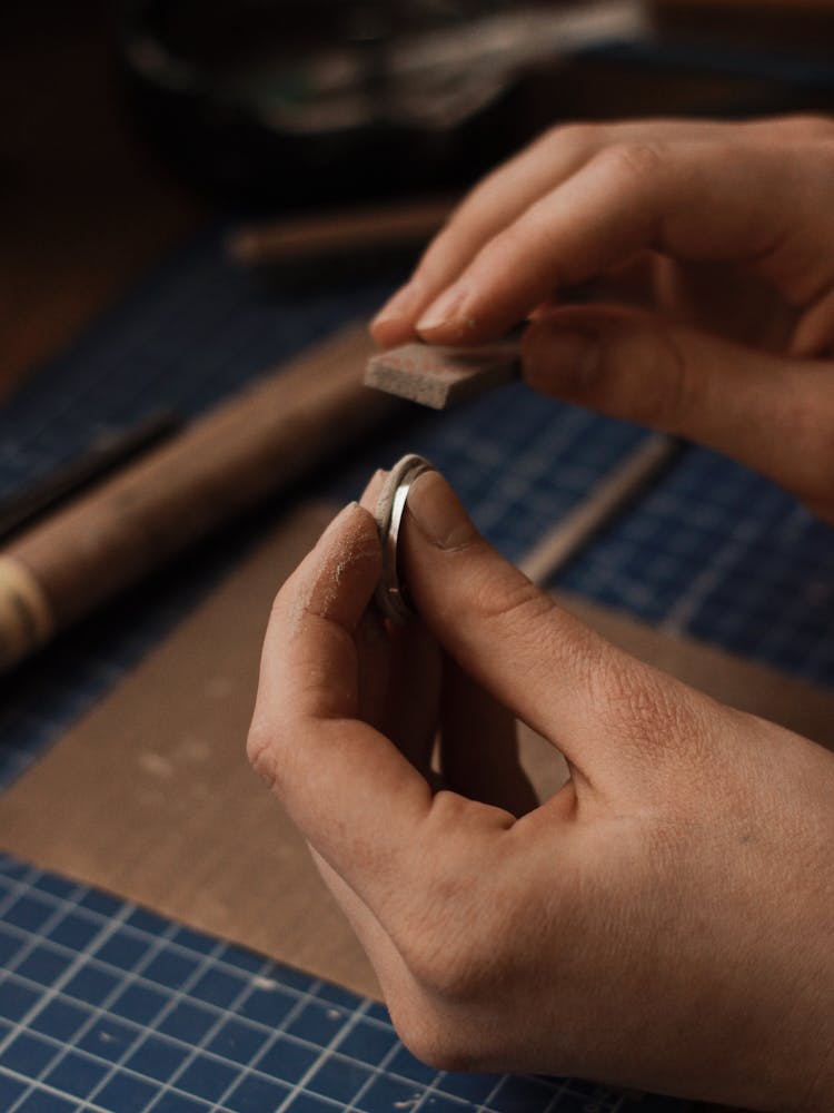 Hands Of A Person Polishing A Metal Object