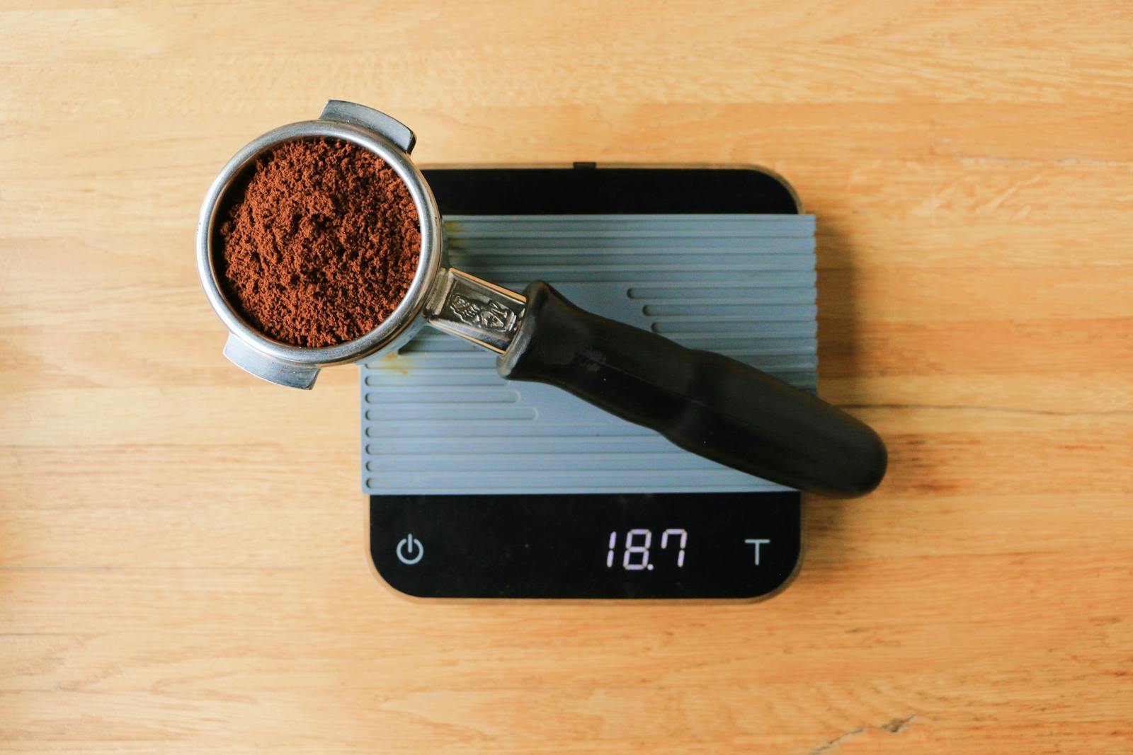 Portafilter resting on a digital scale for dosing coffee.