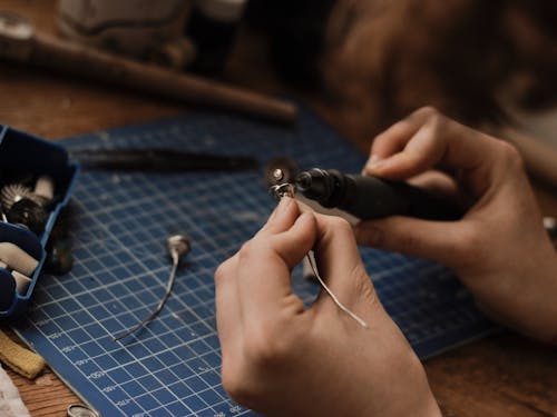 A Person Polishing a Silver Metal Piece