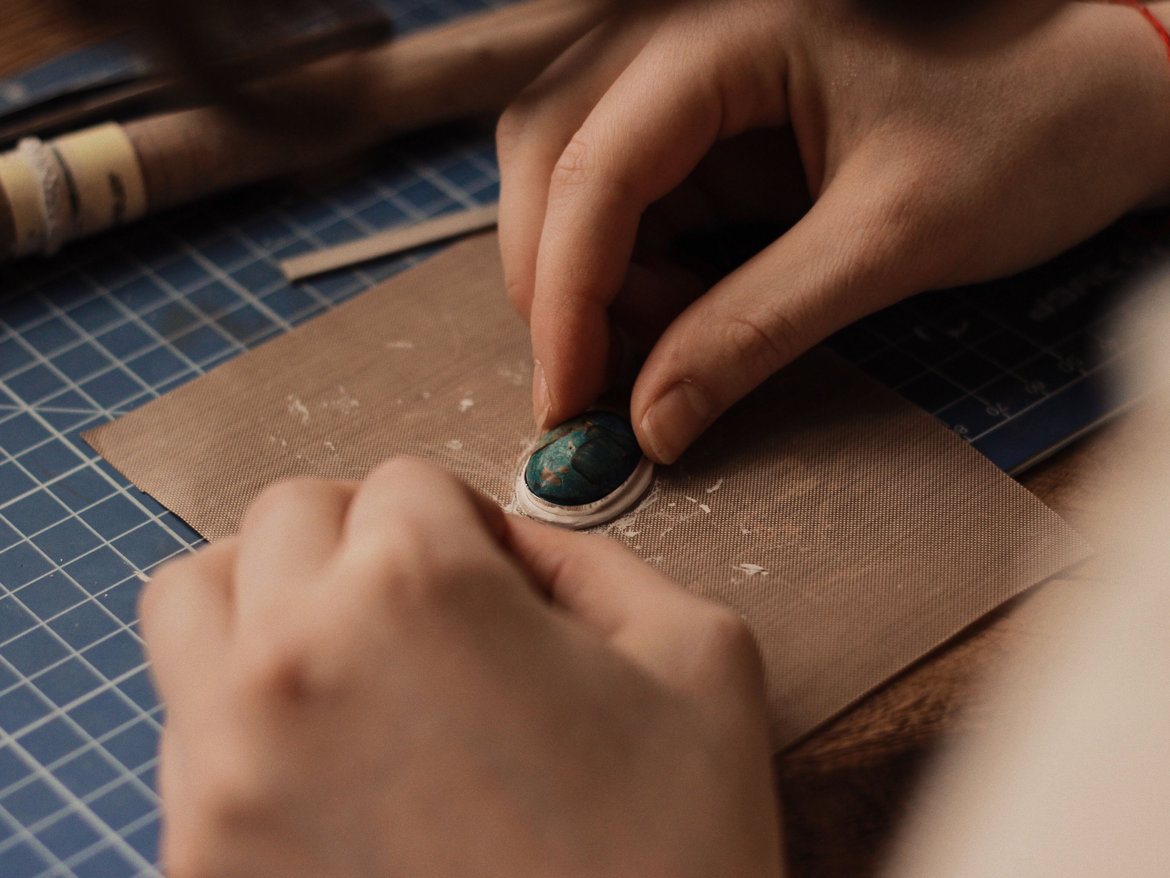 Jeweller refining a piece of metal jewellery at a workbench