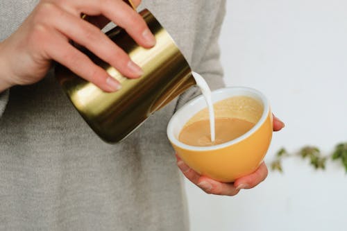 Free A Person Holding a Cup of Coffee with Milk Stock Photo