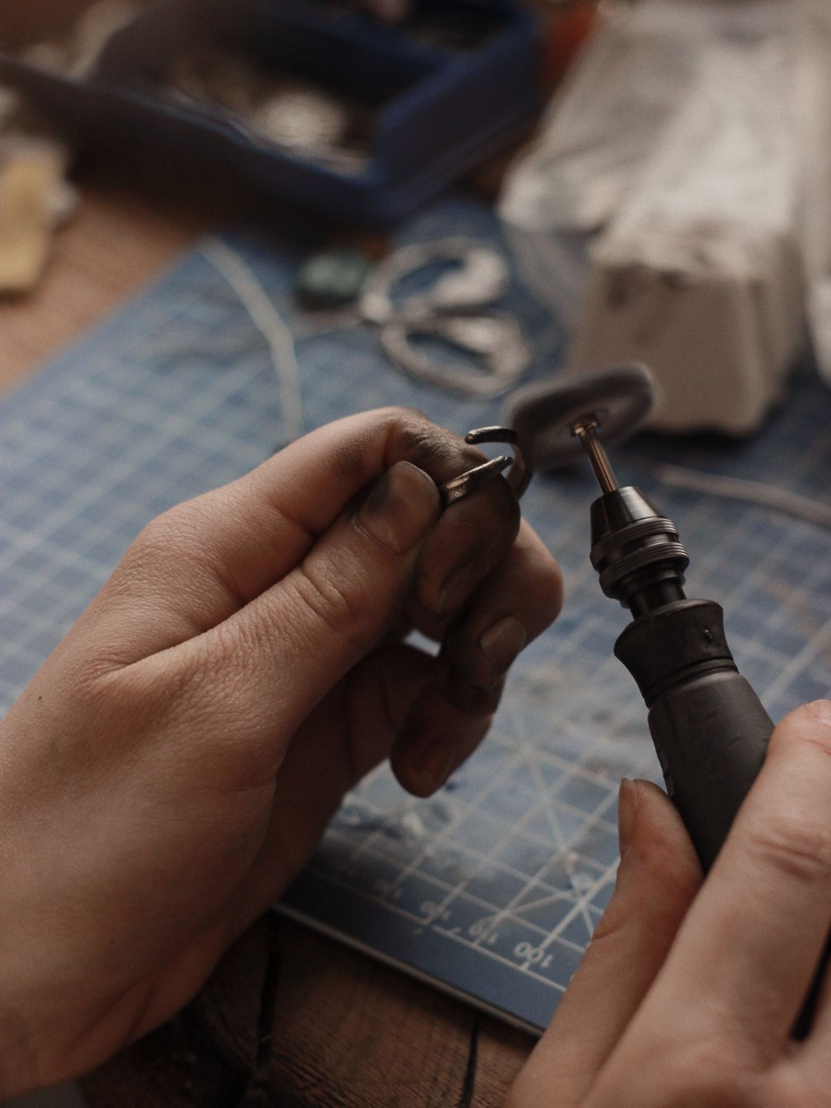 Manos de artesano puliendo joyería de plata en un taller