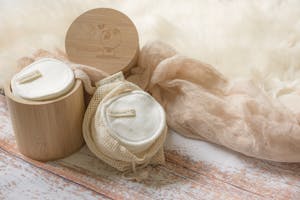 Bamboo Container with White Cotton Pads Beside the Cotton Scrim Fabric
