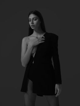 Sophisticated black and white portrait of a woman in stylish fashion attire, exuding elegance.