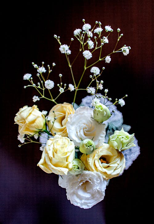 From above of elegant bouquet of fresh yellow roses arranged with white lisianthus and common gypsophila flowers