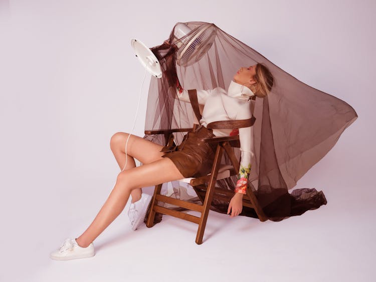 Stylish Woman On Chair With Fan