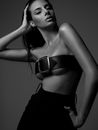 Black and white sexy young female with hand in pocket wearing belt on breast