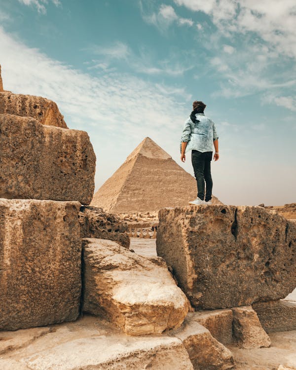 Путешественник, стоящий на каменном памятнике в пустыне