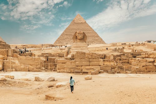 Free Back view of unrecognizable man walking towards ancient monument Great Sphinx of Giza Stock Photo