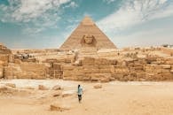 Back view of unrecognizable man walking towards ancient monument Great Sphinx of Giza