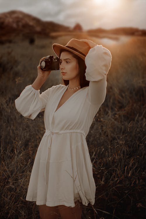 Woman in White Dress Holding Camera