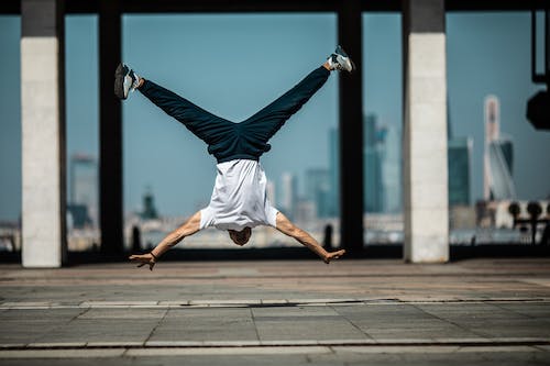 Free A Man in White Shirt and Blue Pants in Upside Down Position Stock Photo