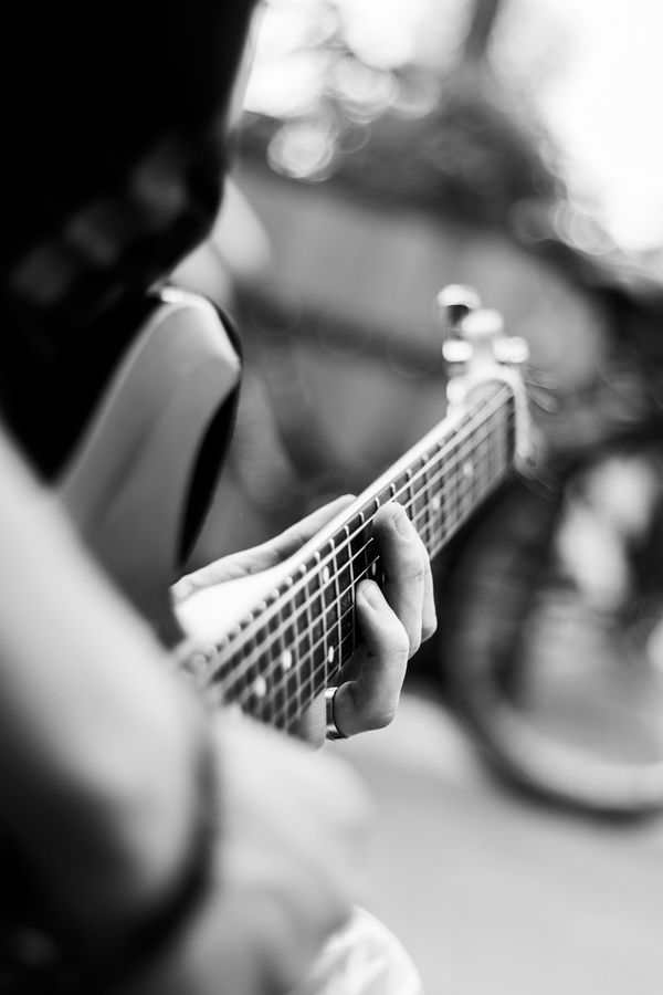 Handen op de hals van een gitaar